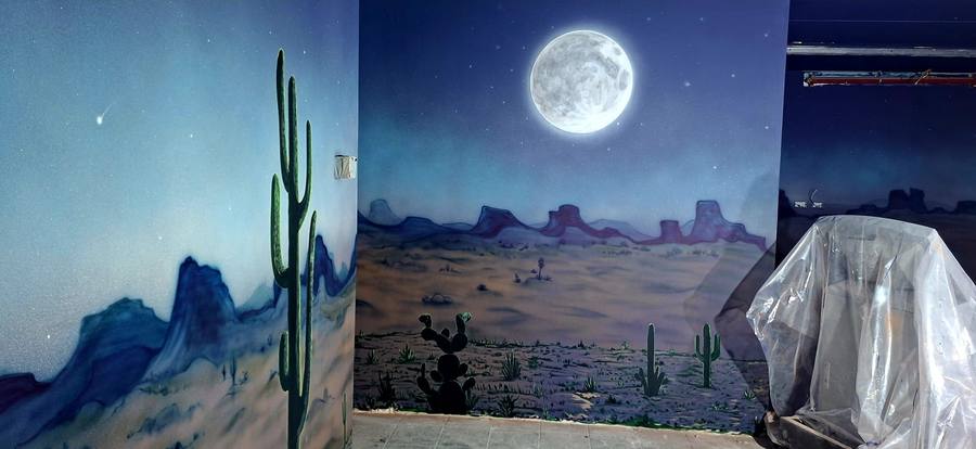 ציור קיר של נוף מדברי עם עומק ואווירה חמה